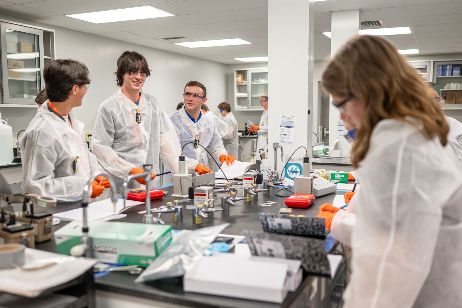 NCSS students talk at a lab bench during a laboratory session